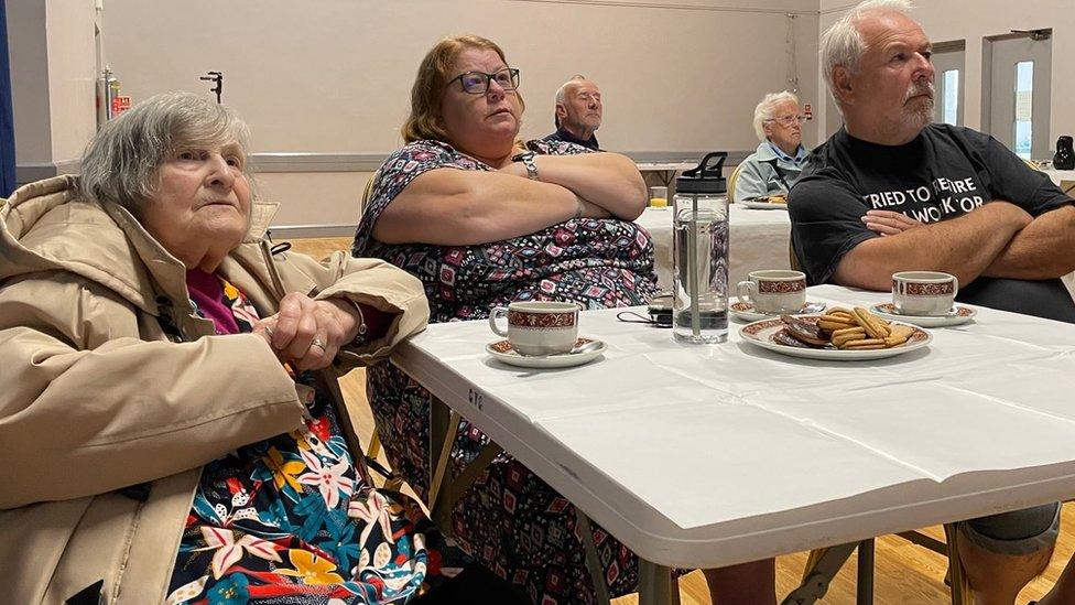 Winfred Horton and Beth Cannan watching the funeral