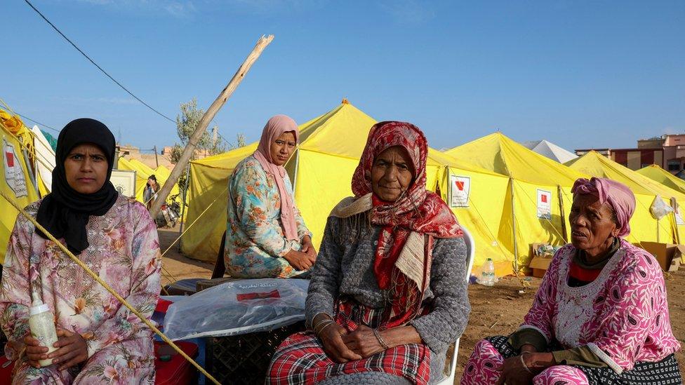 Family members Fatima Bejjar, Melika Ouabella, Yemna Bejjar and Fadma Bejjar sit next to tents in the aftermath of a deadly earthquake in Amizmiz, in Morocco