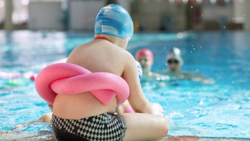 Overweight child by a swimming pool