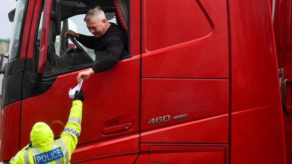 Police officer checking the documentation of a lorry driver at Dover