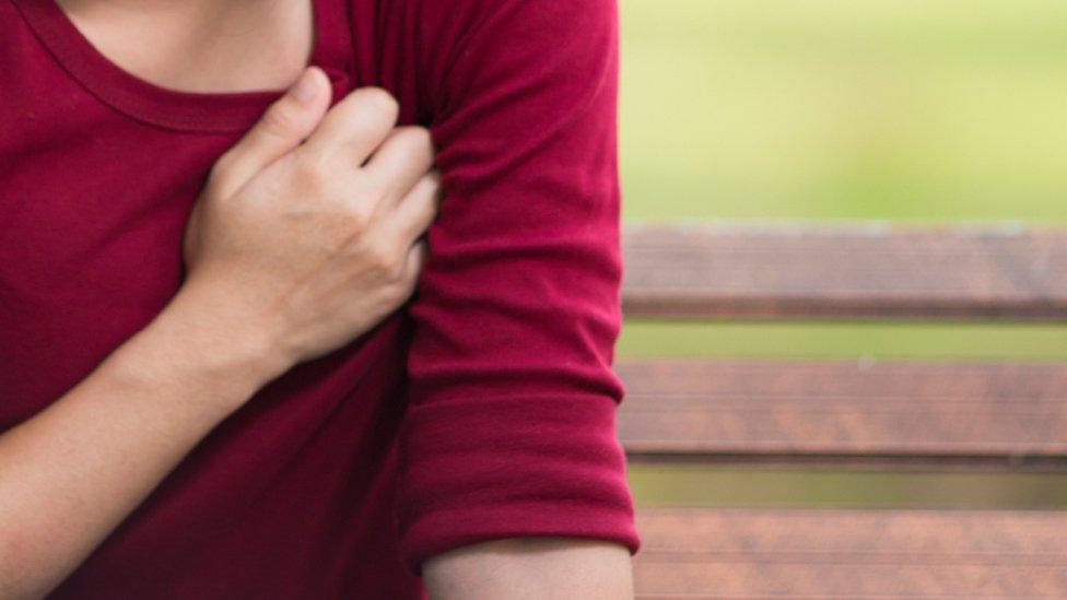 Woman holds chest