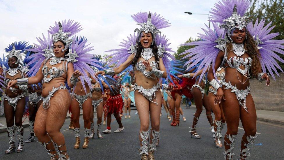 Samba dancers dance behind a Brazilian-inspired float