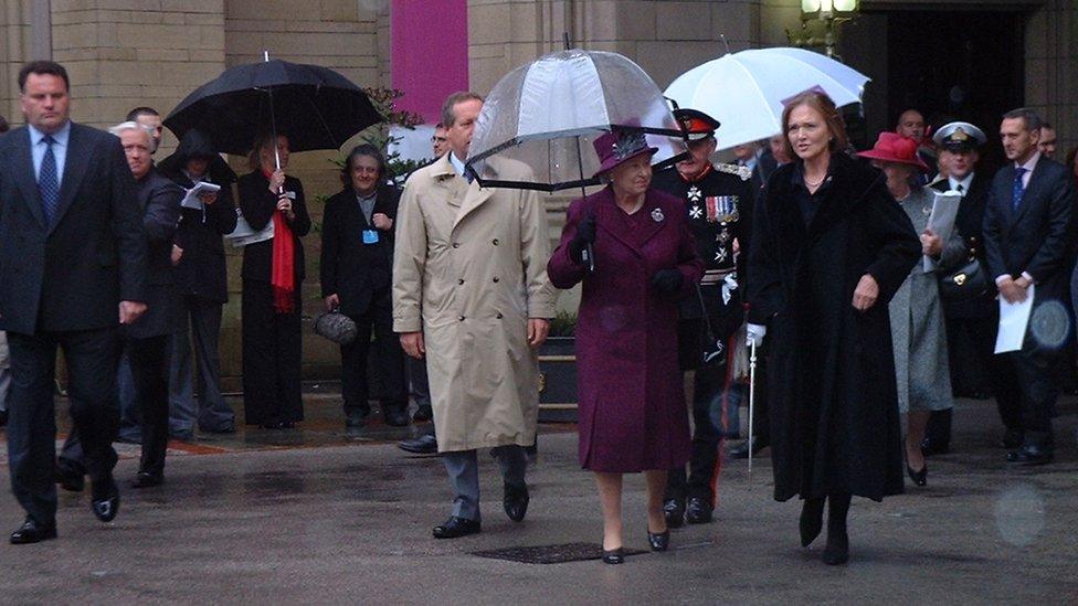 The Queen in Manchester under an umbrealla