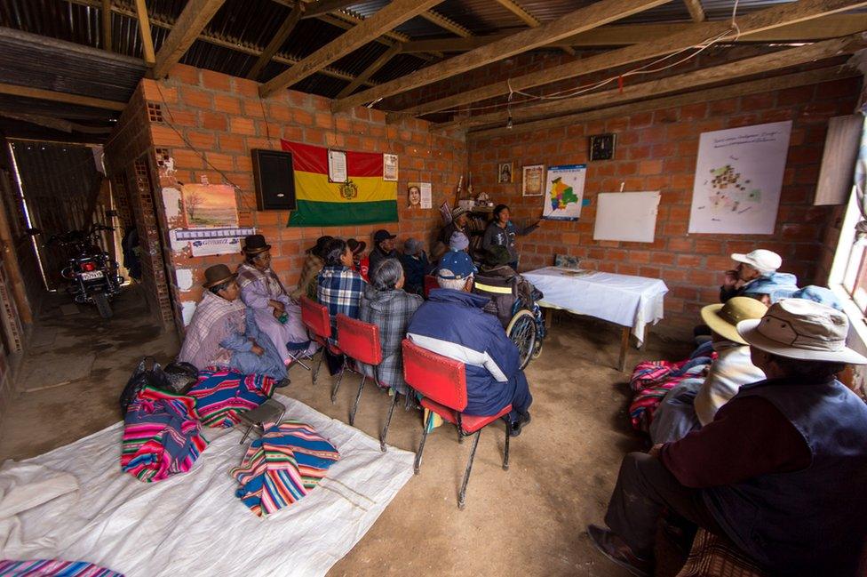 A group of students look at a map in El Alto