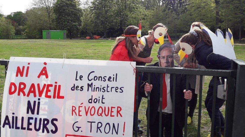 Protesters dressed as chickens call for the mayor to be removed