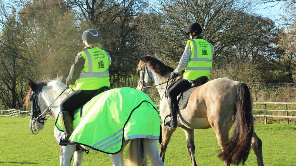 Volunteers riding horses