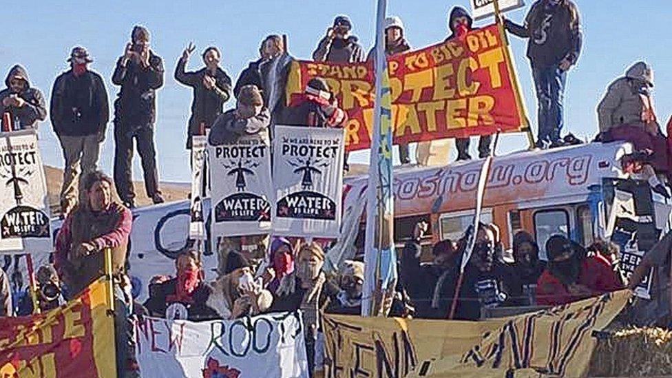 A handout picture made available by the Morton County Sheriff"s Department shows protesters holding placards during a demonstration against the North Dakota oil pipeline project, along the Dakota Access Pipeline construction site, in Morton County, North Dakota, USA, 27 October 2016.