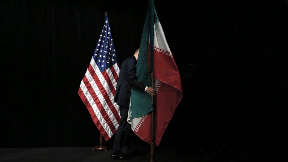 Member of staff removes the Iranian flag from the stage after a group picture with foreign ministers and representatives of Unites States, Iran, China, Russia, Britain, Germany, France and the European Union during the Iran nuclear talks at Austria International Centre in Vienna, Austria on 14 July 2015.