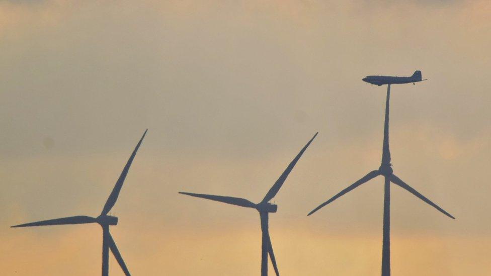 Plane over wind turbines