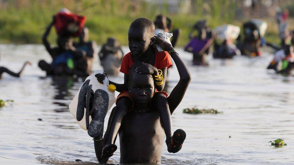 children cross water to register for aid