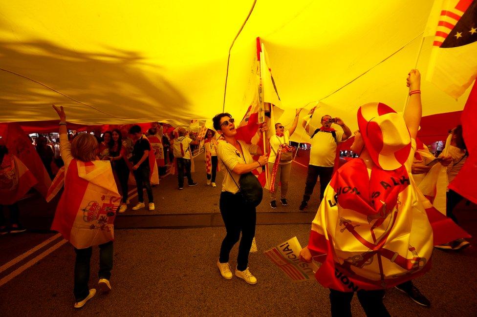 Supporters of Spanish unity walk under a large Spanish flag during a demonstration to call for co-existence in Catalonia and an end to separatism, in Barcelona, Spain, October 27, 2019