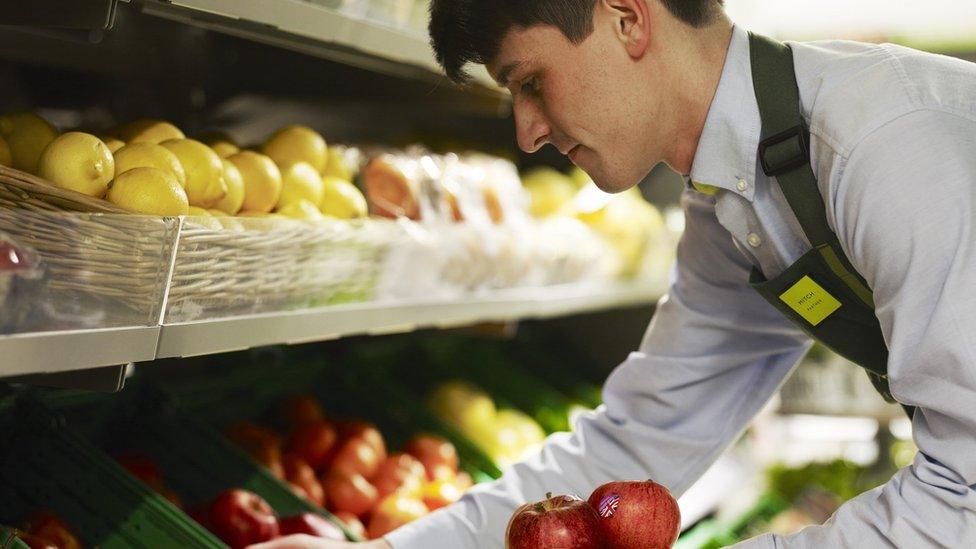 Waitrose staff shelving fruit