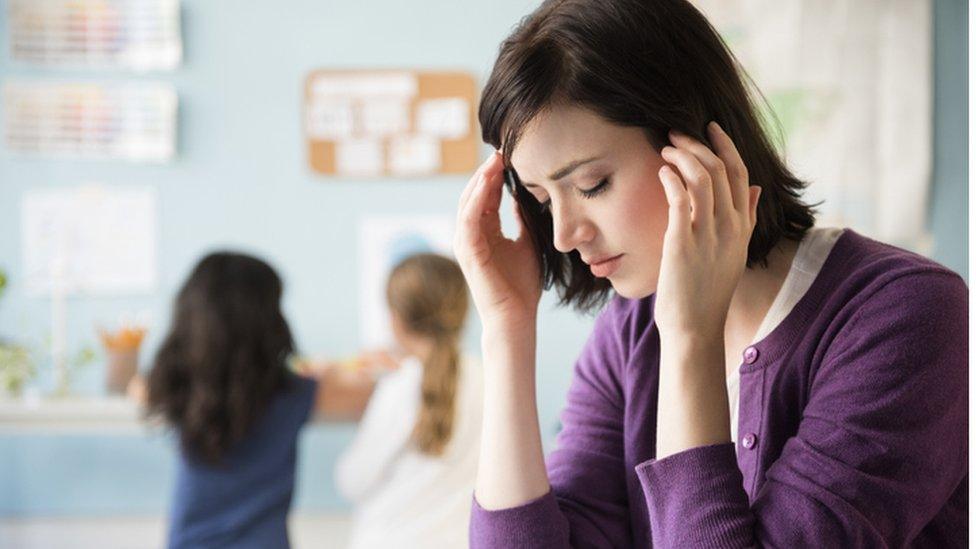 Teacher looking stressed in classroom