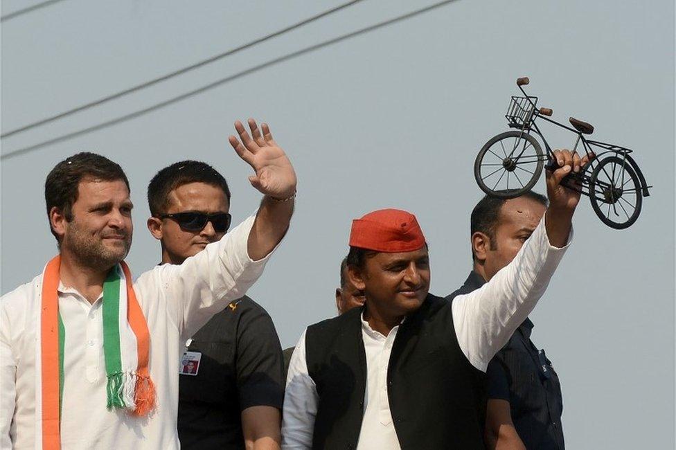 Uttar Pradesh Chief Minister and Samajwadi Party leader Akhilesh Yadav (R) and Congress Vice President Rahul Gandhi (L) wave to the crowd during a joint roadshow in support of their state assembly election party candidates in Varanasi on March 4, 2017.