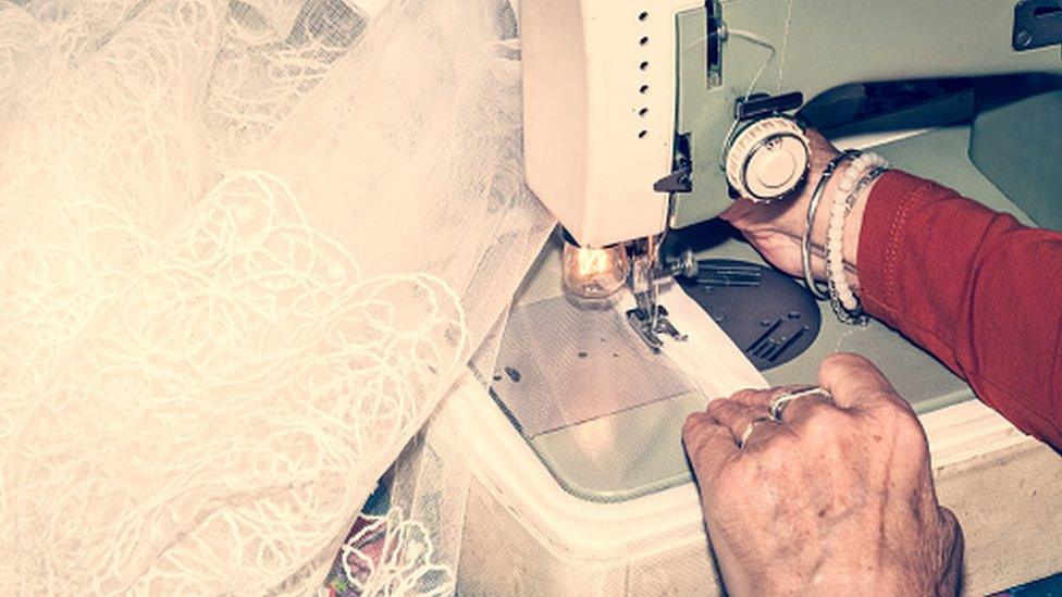 Woman sewing a wedding dress