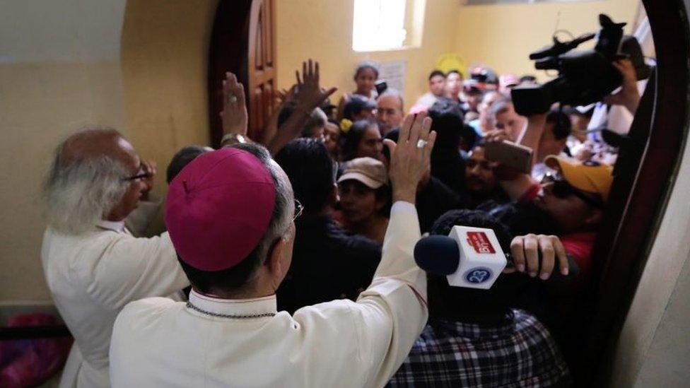 Cardinal Leopoldo Brenes (L) and bishop Silvio Baez try to calm members of the pro-government Sandinista youth down, after arriving at the San Sebastian Basilica in Diriamba, Nicaragua, on July 9, 2018