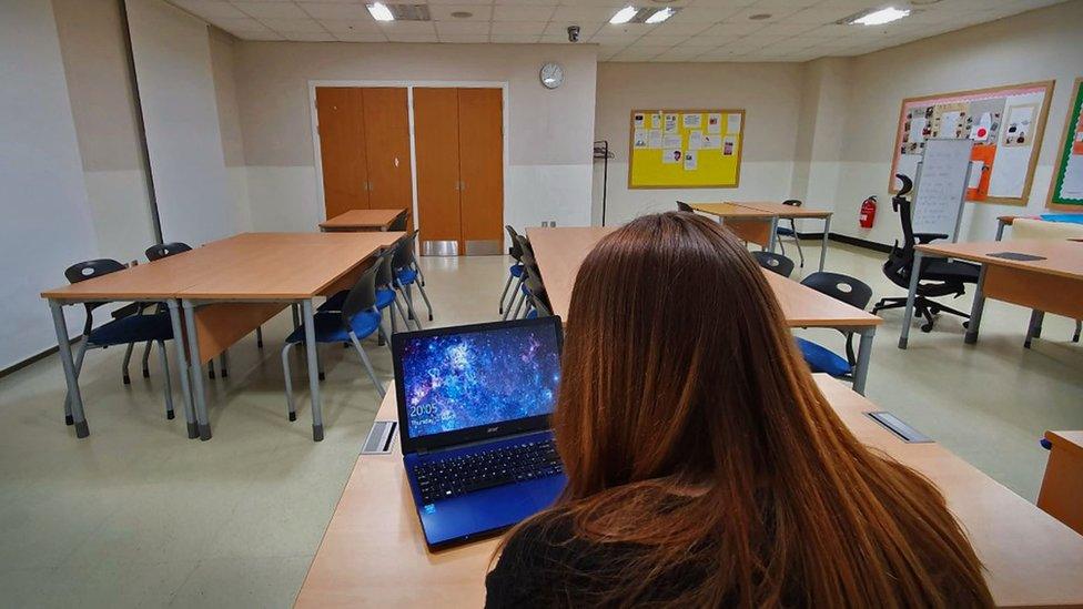 Alice at her laptop in an empty classroom