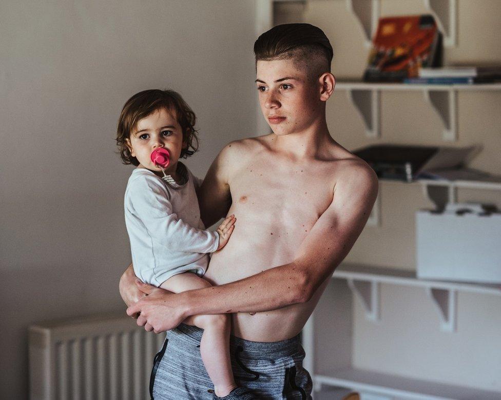 A boy holds a baby