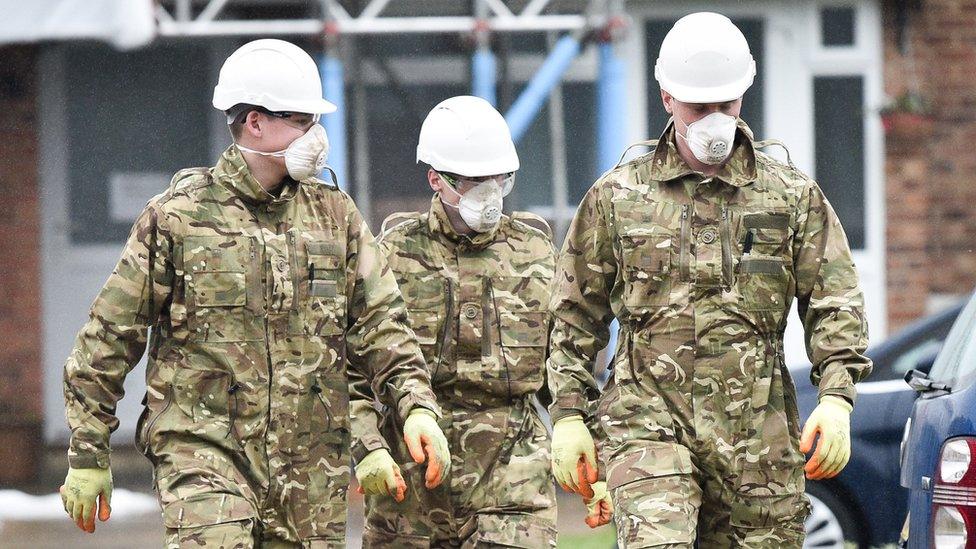 People dressed in British Army fatigues walk away from the Skripals' house in Salisbury