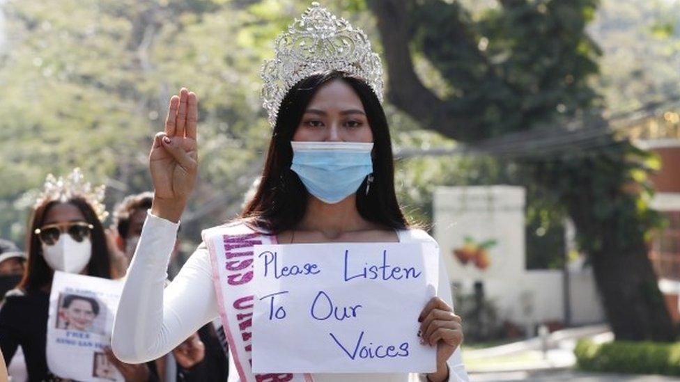 Participants of beauty pageants flash the three-finger salute and hold placards as they march in front of the US Embassy during a protest against the military coup, in Yangon, Myanmar, 10 February 2021