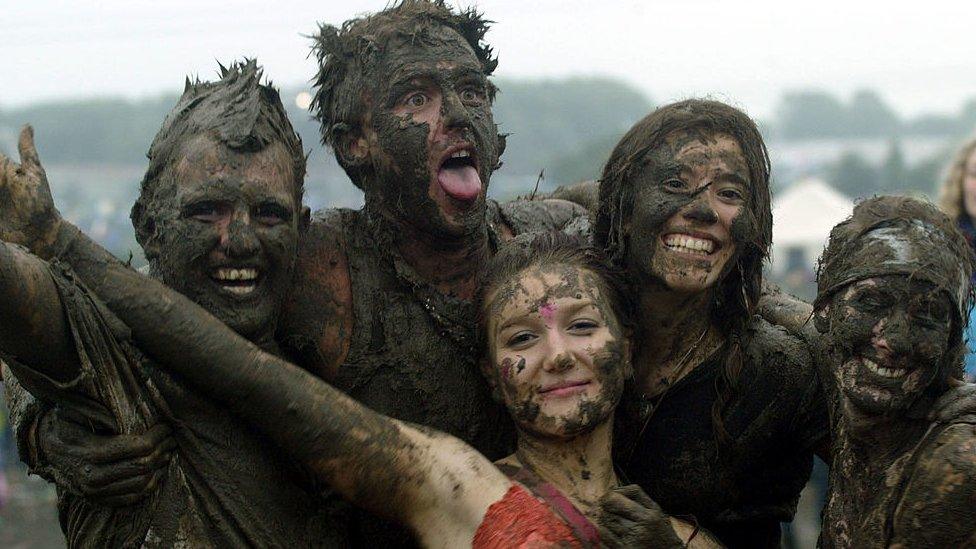 Festival go-ers covered in mud