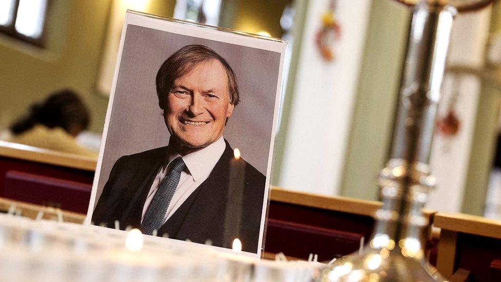 A photograph of Sir David Amess is seen on a table with an arrangement of candles at St Michael's and All Angels Church, Leigh-on-Sea