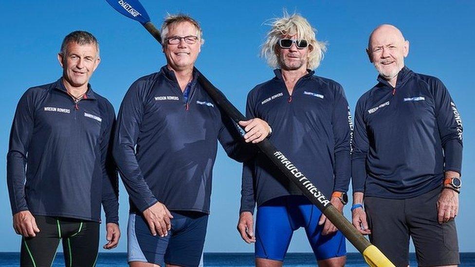 Four men standing on a beach