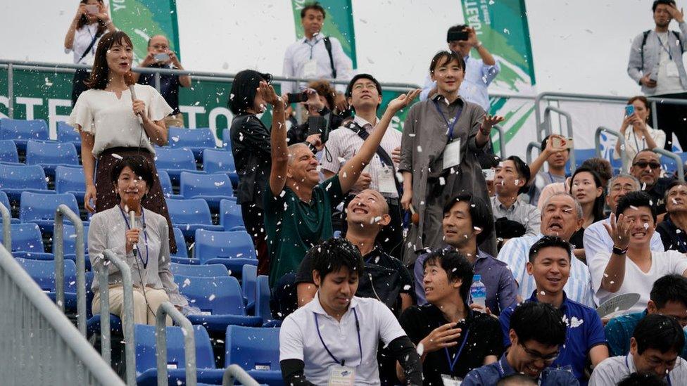people-sitting-in-stands-while-it-snows