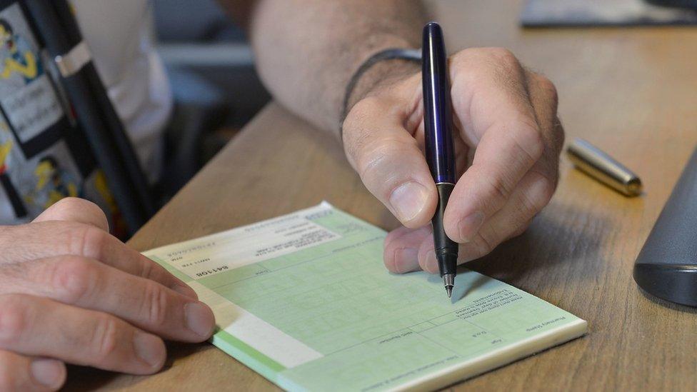 File image of a GP writing out a prescription on a blank pad of paper