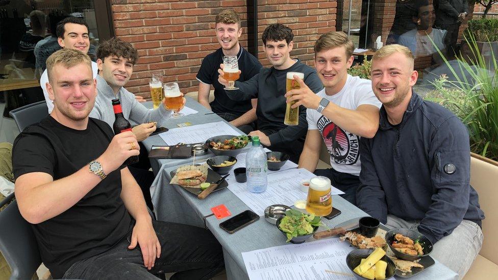 A group of friends having a drink at a table outside Dukes