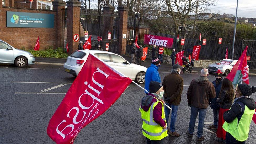 Workers in high vis carry a large nipsa flag.