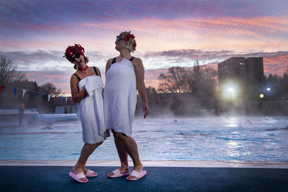 Jessica Walker and Nicola Foster posing by the pool during sunrise before swimming at Charlton Lido in Hornfair Park, London, on its first day of reopening after the second national lockdown ended.