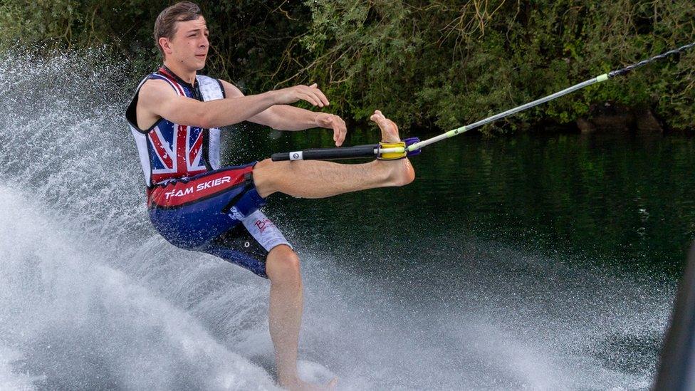 Henry water-skiing with his left leg up