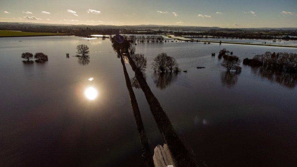 A car turns around to avoid floodwaters on Langport Road, near Muchelney, Somerset.