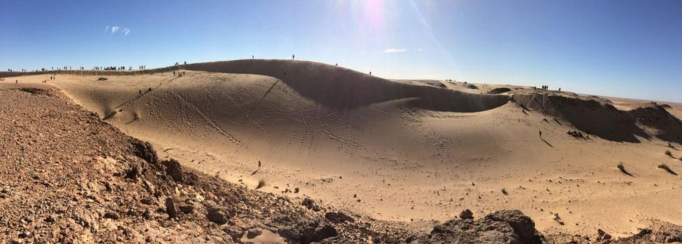 runners in the Sahara Marathon fan across the desert dunes