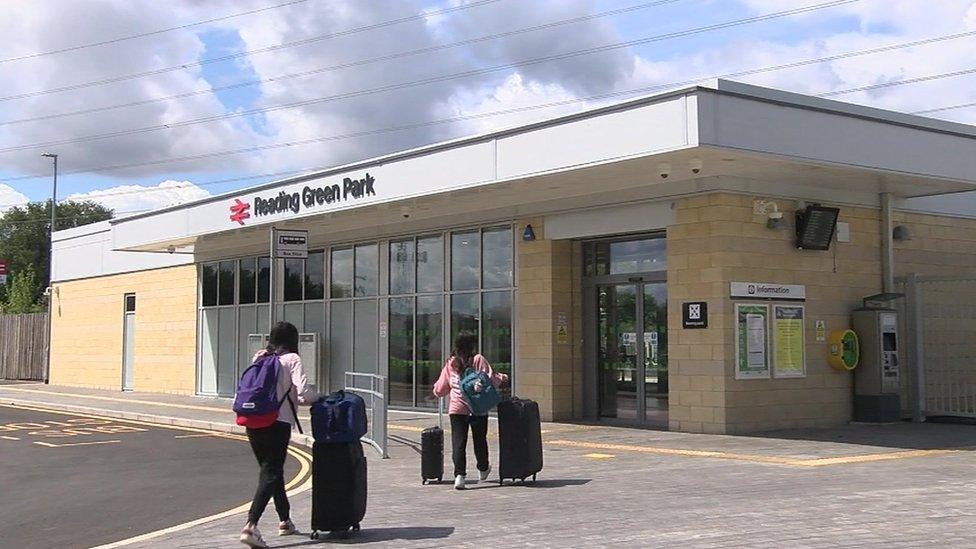 two women with suitcases outside a train station