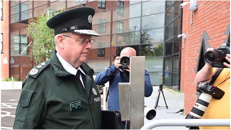 Chief Constable Simon Byrne enters the policing board meeting wearing his police uniform