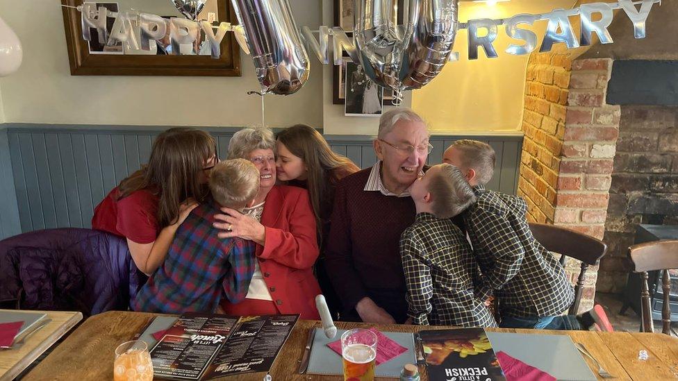 Mr and Mrs Lealan receiving kisses from children