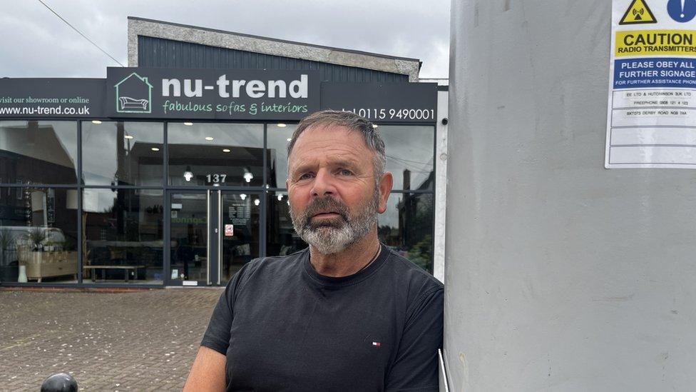 Business owner Mr McGrath next to the pole outside his shop