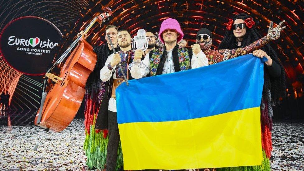 "Kalush Orchestra" pose onstage with the winner's trophy and Ukraine's flags after winning on behalf of Ukraine the Eurovision Song contest 2022 on May 14, 2022 at the Pala Alpitour venue in Turin.