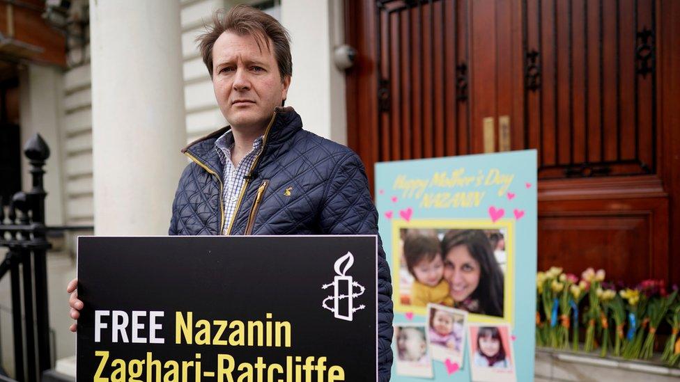 Mr Ratcliffe holds a poster which reads "Free Nazanin"