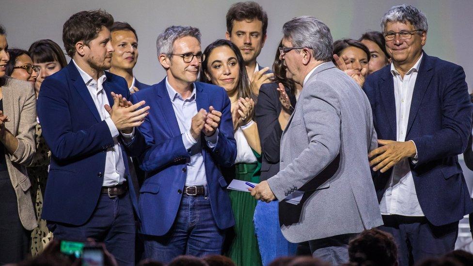 French far-left party La France Insoumise (LFI) leader Jean-Luc Melenchon (2-R) after delivering his speech greets French Green party (EELV) General Secretary Julien Bayou (L) and Socialist party member Stephane Troussel (C) during the launch of the "New Popular Ecological and Social Union" (NUPES) in Aubervilliers, near Paris, 07 May 2022