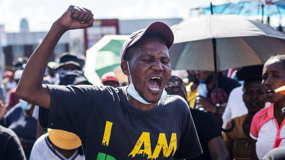 Man waves his fist in the air during a march through Alexandra township, on March 7, 2022