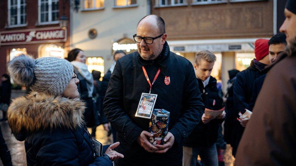 Pawel Adamowicz is seen with a charity bucket talking with citizens in Gdansk