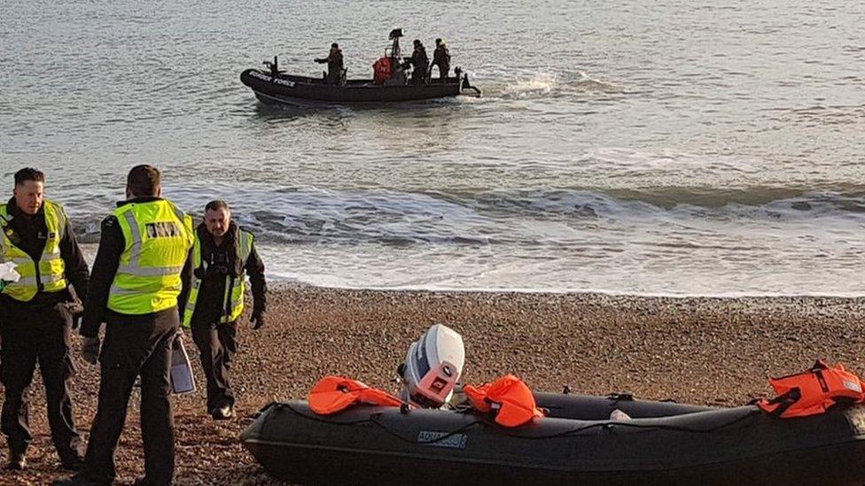 Border force officials by a dinghy