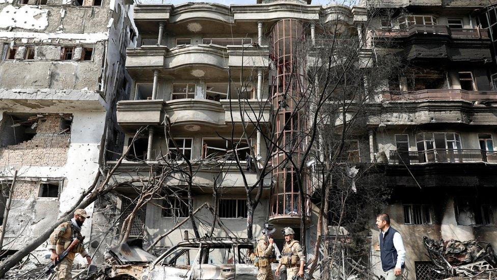 Afghan security forces inspect the site of Sunday's attack in Kabul, Afghanistan