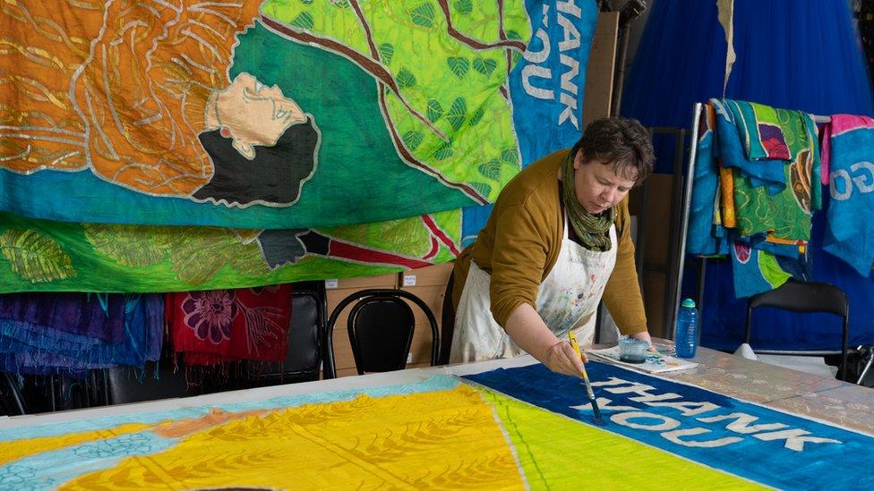 A woman painting a giant scroll