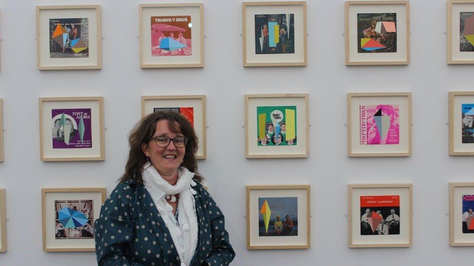 Dynes o flaen gwaith celf // A woman stand in front of artwork