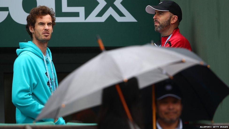 Andy Murray looks out on to rainy tennis court