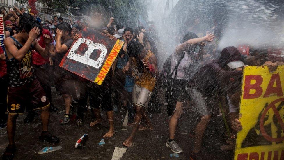 Philippine protesters are soaked by riot police while marching against Donald Trump's visit